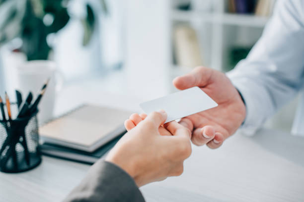 cropped image of patient giving empty card to doctor in clinic